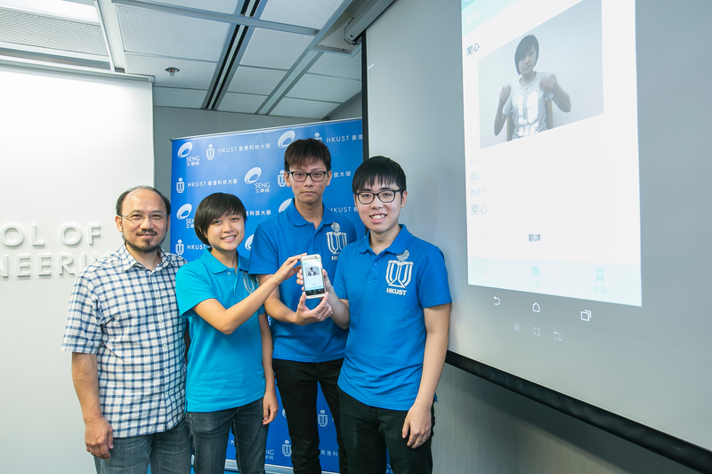 (from left) HKUST's Prof Brian Mak and students Mary Leung, Kelvin Yung and Ken Lai show their app on the mobile phone.